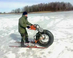 Мужчина едет на мотосанях по льду