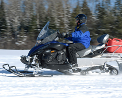 Мужчина едет на снегоходе Yamaha Venture
